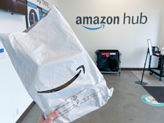 An amazon packaged held up inside an amazon Hub order pickup and return center