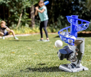 kids playing with a baseball pitching machine