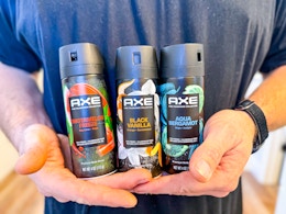 3 Axe Body Sprays held in men's hands (close up shot)