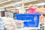 walmart basket with person putting a pink shirt in