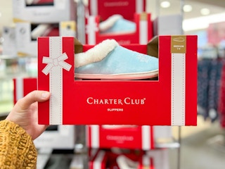 someone holding up a boxed set of slippers at macy's