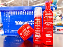 three cantu hair care items on table in front of walmart hand cart
