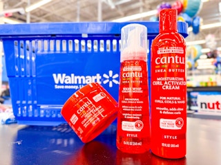 three cantu hair care items on table in front of walmart hand cart