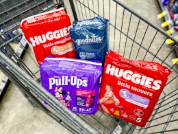 packs of huggies, goodnites, and pull-ups in a shopping cart