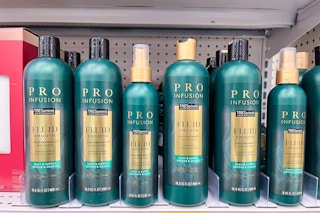 hand holding a bottle of tresemme pro shampoo in an aisle at target