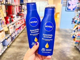 hand holding two nivea body lotions