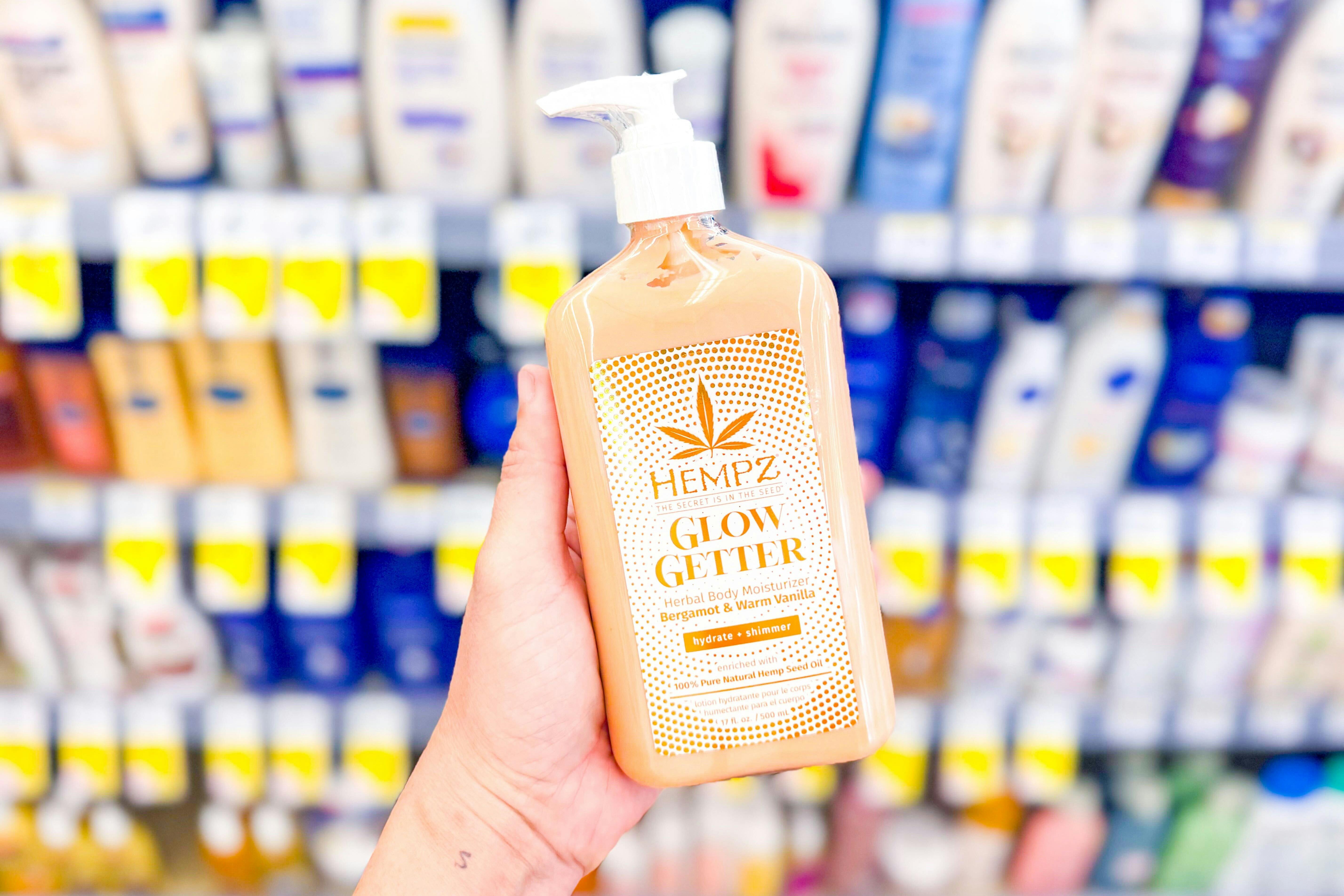 hand holding a bottle of hempz lotion in a store aisle