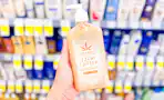 hand holding a bottle of hempz lotion in a store aisle