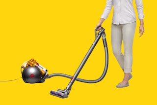 Image of person using the Dyson Big Ball Canister Vacuum (stock image) over yellow background