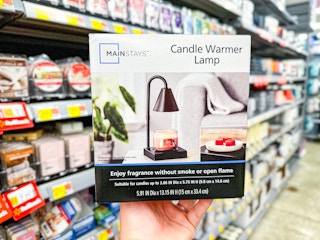 Mainstays Candle Warming Lamp held up in candle isle of Walmart store