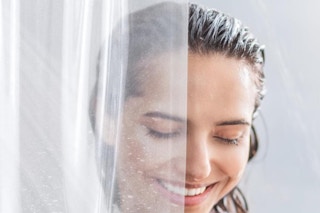 a woman next to a clear shower curtain