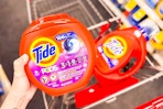 hand holding large tide pods container