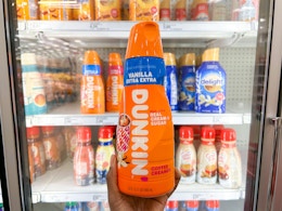 hand holding bottle of Dunkin' coffee creamer