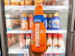 hand holding bottle of Dunkin' coffee creamer