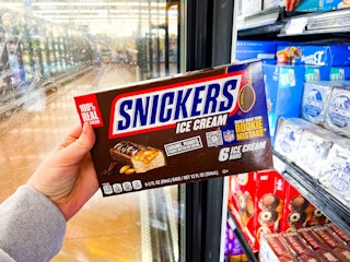 hand holding a 6-count of Snickers Ice Cream bars