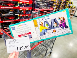 person holding a $149.99 price tag by a yourigami play fort in a cart