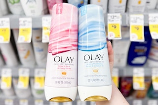 hand holding two bottles of olay indulgent body wash