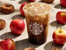 a Starbucks apple crisp oatmeal shaken espresso drink set against a background of apples and donuts