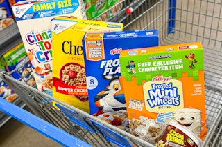 cinnamon toast crunch, cheerios, frosted flakes, frosted mini wheats, cocoa pebbles cereal in a shopping cart