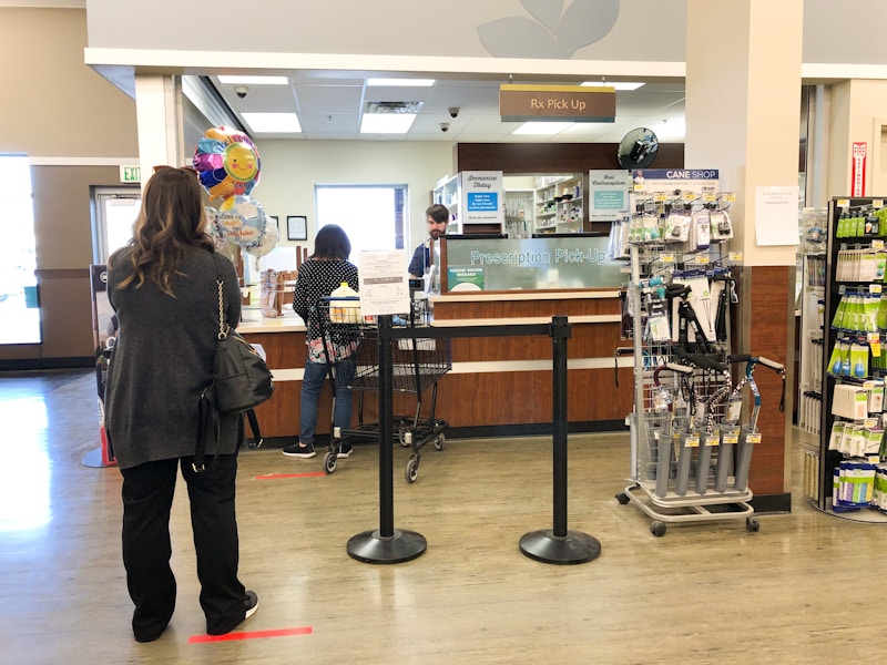 A woman waits in line at the pharmacy at Albertsons.