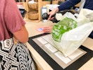 An employee at World Market scanning a coupon on a cell phone.
