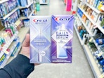 hand holding crest whitening pen and serum in walgreens