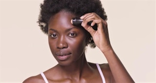 A woman applying a Revlon volcanic face roller on her face