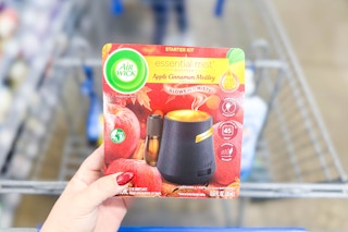 hand holding the packaging of an Air Wick diffuser starter kit