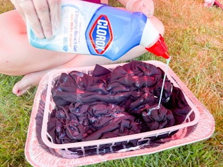 pouring Clorox bleach on tie dye clothes