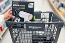 hand holding nuvomed massage gun in a walgreens shopping basket