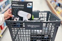 hand holding nuvomed massage gun in a walgreens shopping basket