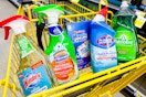 mr. clean, clorox, palmolive, scrubbing bubbles, windex in a yellow dollar general shopping cart