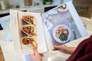 The home chef binder and recipe cards held in a woman's hands.