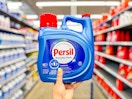 hand holding a bottle of persil liquid detergent in walmart aisle