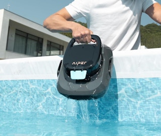 a person pulling out a robot cleaner out of the pool
