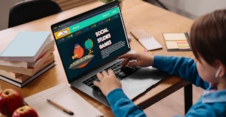 A child using a laptop to look at Social Studies games on a website