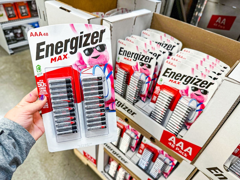 person holding a pack of 48 energizer batteries over the box