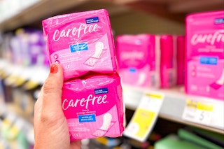 hand holding two stacked packs of liners in front of store product shelf