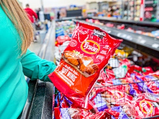 woman holding a bag of tyson anytizers wings at walmart