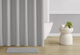 A neutral shower curtain and rug