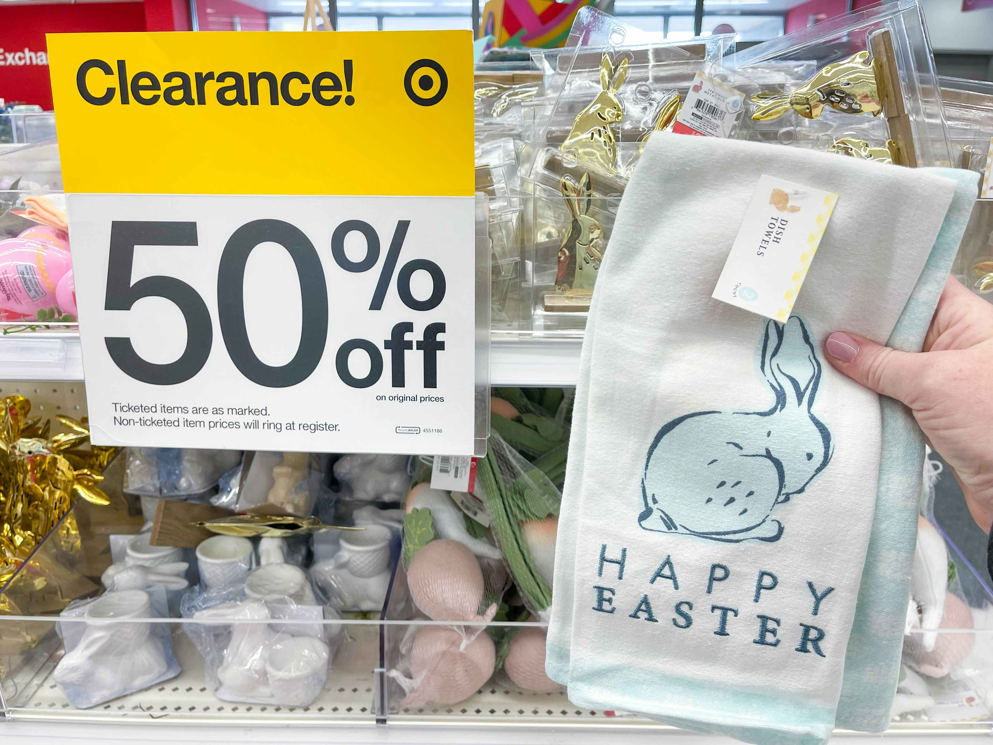 a happy easter hand towel being held in front of clearance sale sign in target