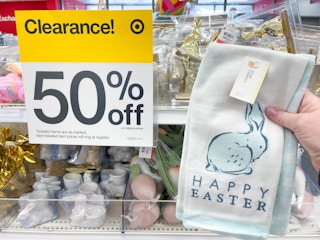a happy easter hand towel being held in front of clearance sale sign in target