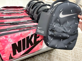 hand holding up nike lunch bag next to other nike bag