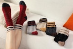 woman wearing socks next to folded pairs