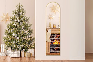 Lifestyle image of the EDX Arched Full Length Mirror in the color gold (Christmas tree in the background)