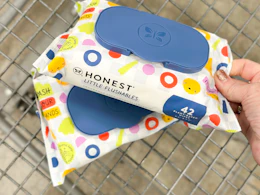 hand touching honest baby wipes packs in cart