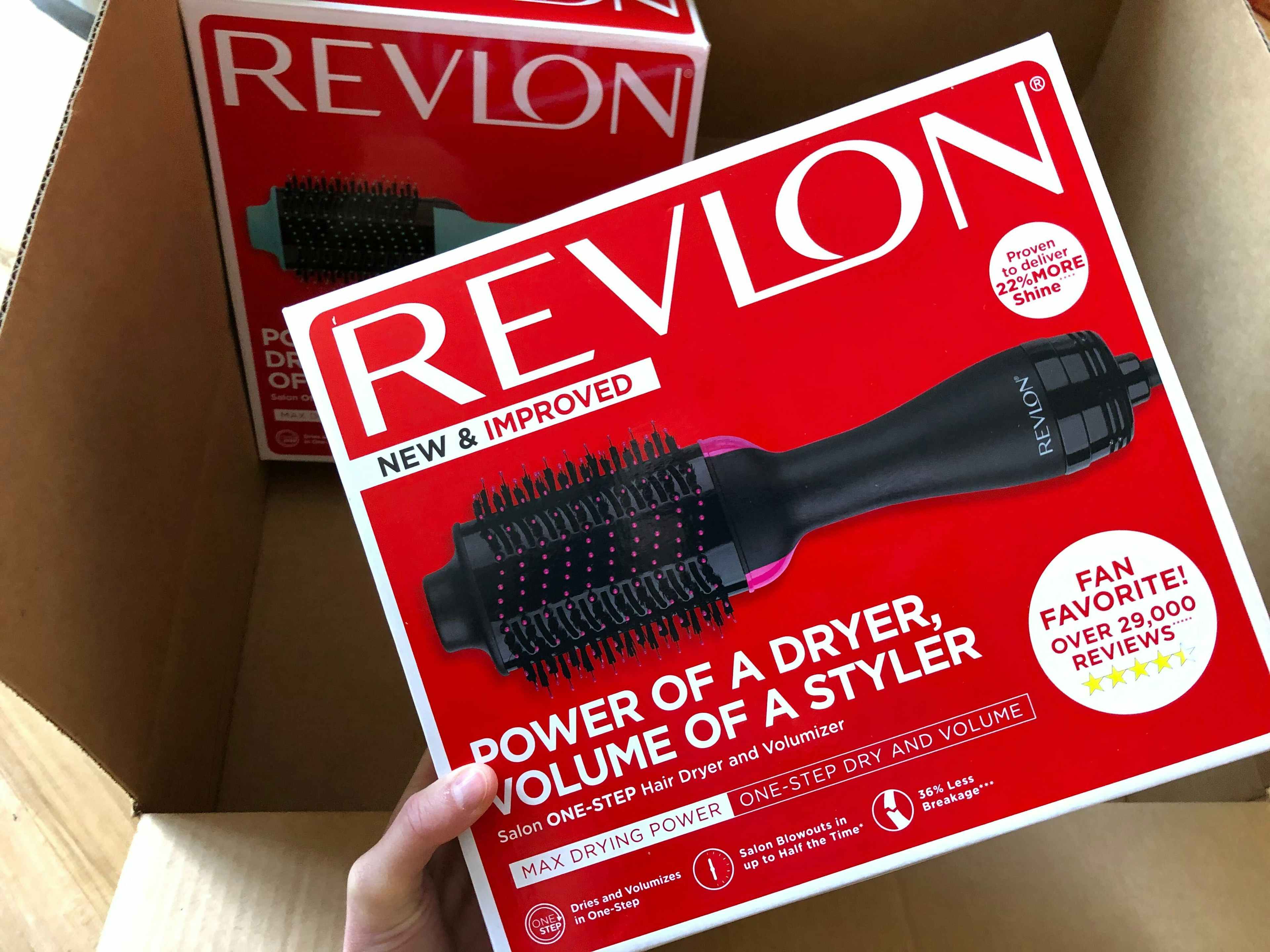 hand holding a box containing an Revlon one step hair dryer