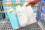 hand placing dove body wash in shopping cart