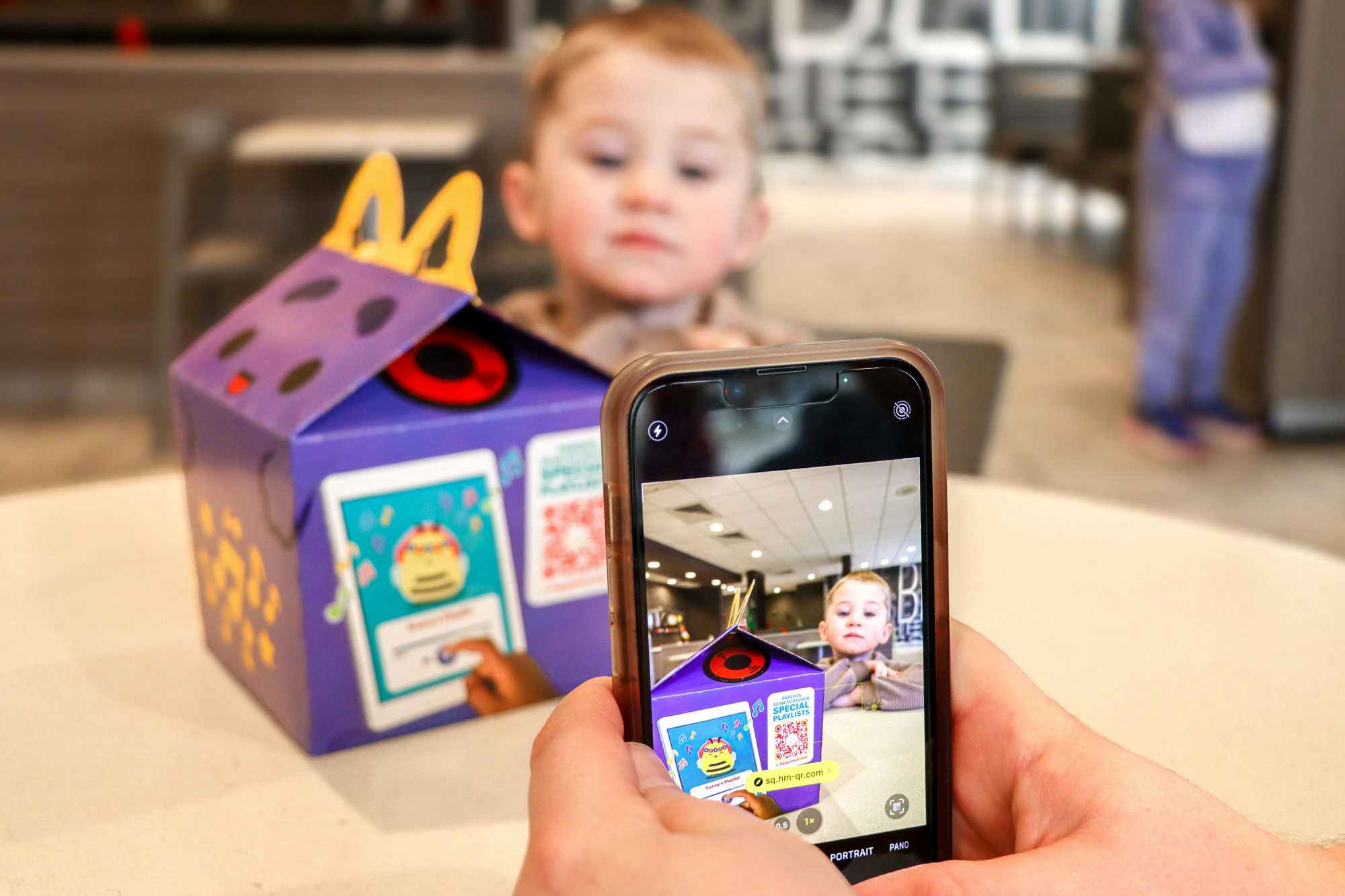 a person scanning a QR code on a happy meal
