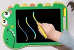 child writing on dinosaur LCD writing tablet